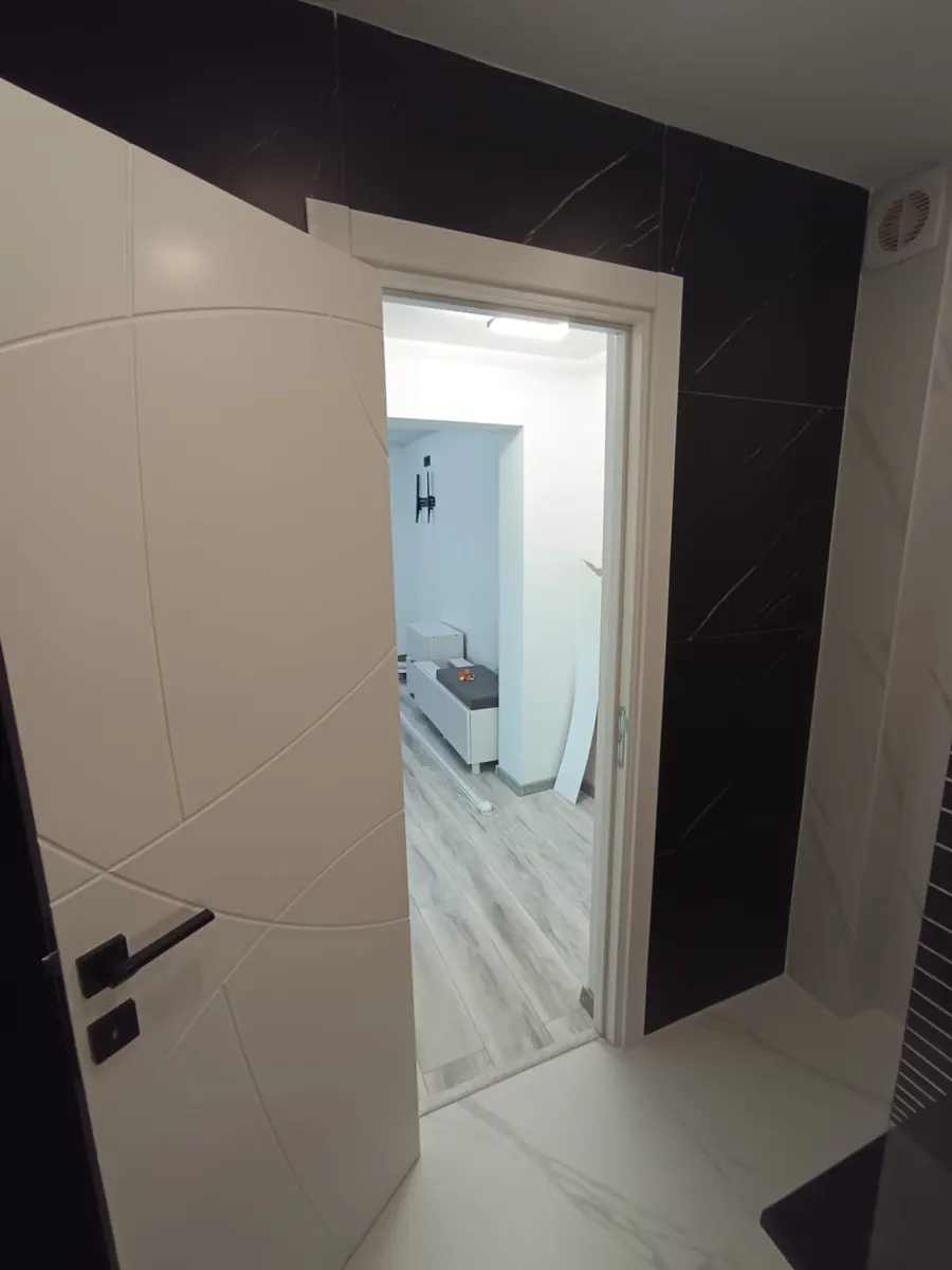 Acceso al baño con revestimiento negro y blanco