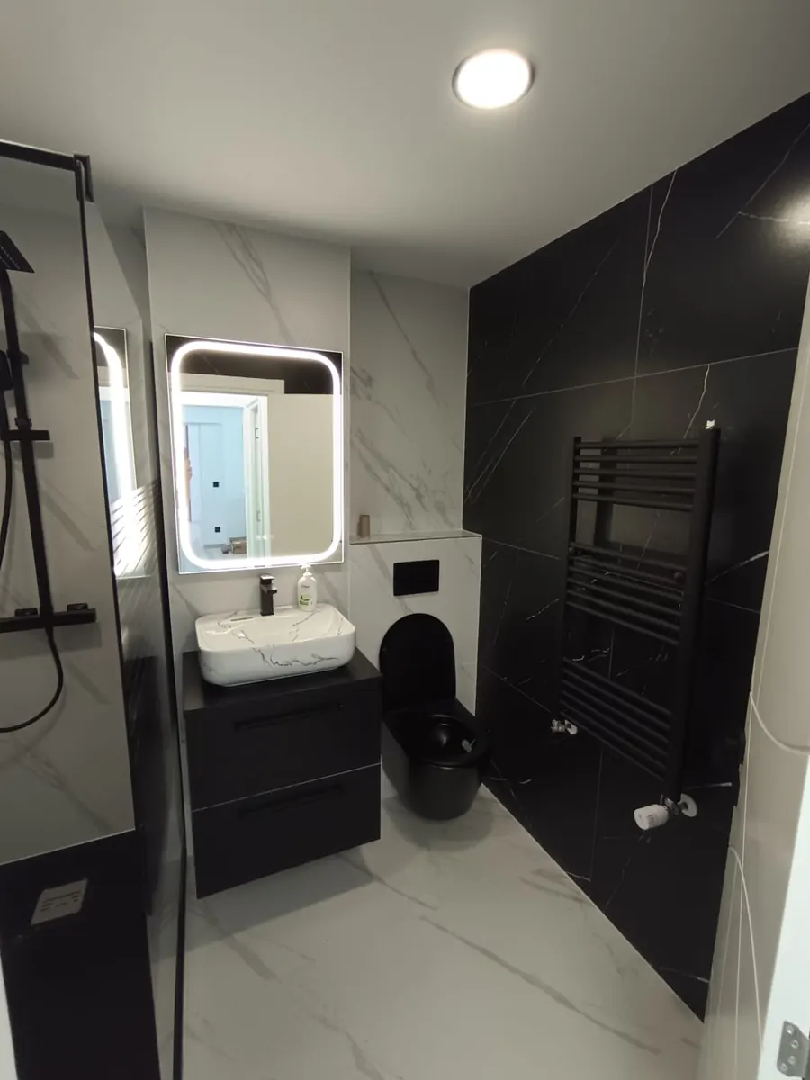 Baño compacto con mueble suspendido, inodoro suspendido y toallero